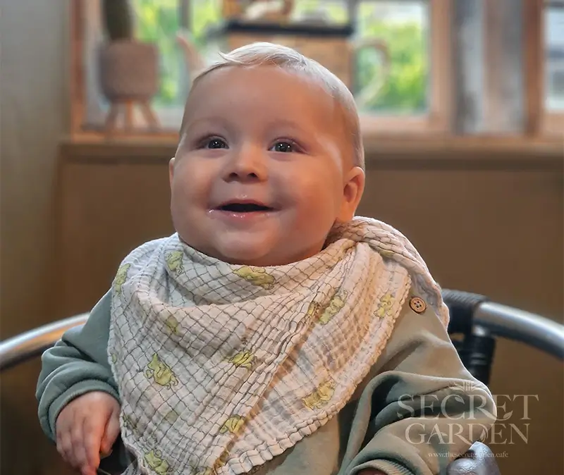 Baby Elijah sitting at The Secret Garden Cafe in Dorchester